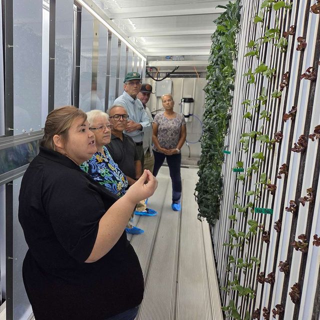 A student explaining the vertical grow towers to visitors