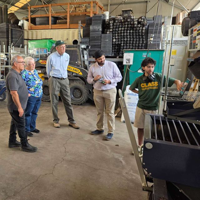 Visitors touring the farm equipment shop with a student guide