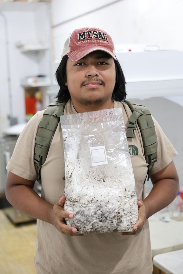 A student holding a colonized mushroom grow bag